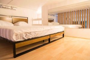 1 dormitorio con 2 camas y espejo en Balnéo, Ecran LCD, Literie 160x200, en Lyon