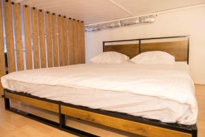 1 cama con sábanas blancas y almohadas en una habitación en Balnéo, Ecran LCD, Literie 160x200, en Lyon