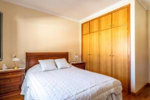 Schlafzimmer mit einem Bett und Holzschränken in der Unterkunft Harmonia Apartment by Atlantic Holiday in Machico