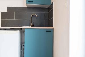 cocina con fregadero y armario azul en Balnéo, Ecran LCD, Literie 160x200, en Lyon