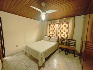 a bedroom with a bed and a ceiling fan at Condomínio Fazenda Garatucaia in Angra dos Reis