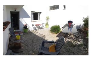 een patio met stoelen, een tafel en een grill bij L'appartement in Le Pradet
