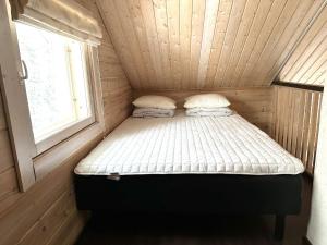 een klein bed in een kamer met een raam bij Hietavilla Aurora in Ruka