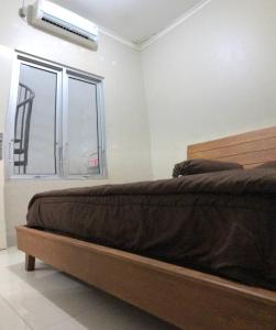 - une chambre avec un lit et une fenêtre climatisée dans l'établissement Homestay Lavender C6 Palembang, à Palembang