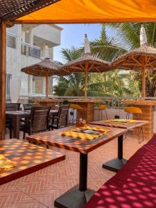 a patio with tables and chairs and umbrellas at Francesca Guest House in Dakar