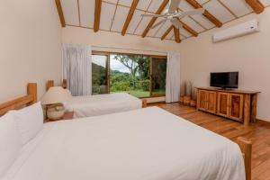 1 dormitorio con 2 camas y TV de pantalla plana en Two Bedroom Villa - Higueron, en Islita
