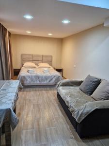 um quarto com duas camas e um sofá em Guest house Lana em Tbilisi