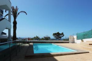 una piscina con una palmera al lado de una casa en Best views Bello Horizonte, en San Agustín