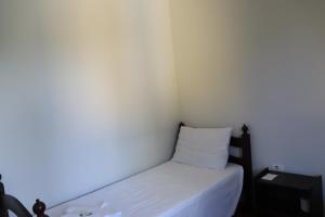 um pequeno quarto com uma cama e uma almofada em Camping Pousada Ilha do Mel - Frente ao Mar em Boraceia