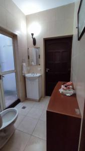 a bathroom with a sink and a toilet and a door at Tierra del sol Apart in La Banda
