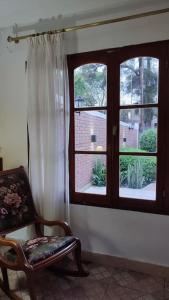 a room with a window with a chair and a chair at Tierra del sol Apart in La Banda