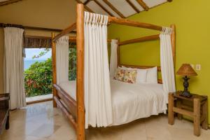 1 dormitorio con cama con dosel y ventana en Three Bedroom Villa - Bouganvilla, en Islita