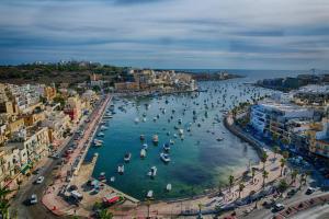 an aerial view of a harbor with people in the water at Apartment in Marsaskala in Marsaskala
