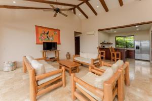 sala de estar con sillas de madera y TV en Three Bedroom Villa - Estrella, en Islita