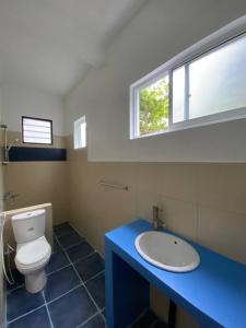 La salle de bains est pourvue de toilettes, d'un lavabo et d'une fenêtre. dans l'établissement Pearl Villa Rooms and Hostel, à Unawatuna