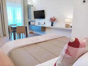 a bedroom with a bed and a table with a tv at Appartamento con Terrazza Fronte Mare in Riccione