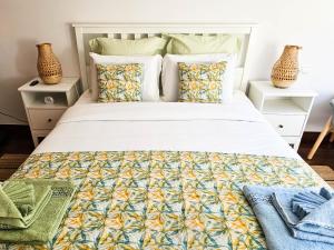 ein Schlafzimmer mit einem großen weißen Bett mit Kissen in der Unterkunft Machico Oasis - Mountainview in Machico