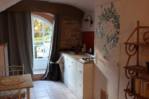 cocina con ventana y nevera blanca en Studio des mésanges, en Saint-Laurent-la-Roche