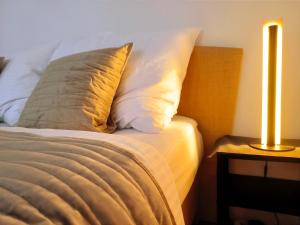 - un lit avec un oreiller et une lampe sur une table dans l'établissement CozyHome Medena Central, quiet premium spot in Old Town, à Bratislava