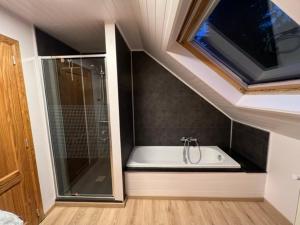 a bathroom with a shower and a bath tub with a window at Villa Du bonheur met Sauna en Jacuzzi in Somme-Leuze +39 photos