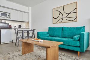 a living room with a green couch and a table at Cabello Square by RentinBA in Buenos Aires