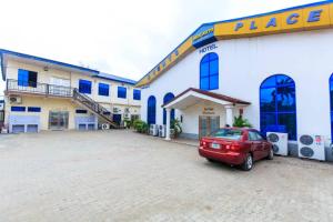 um carro vermelho estacionado em frente a um edifício em BEN AUTO Hotel em Lagos