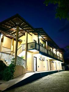 - un bâtiment avec des balcons latéraux la nuit dans l'établissement Camping Pousada Ilha do Mel - Frente ao Mar, à Boraceia