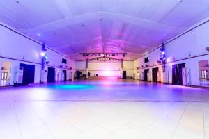 a dance floor in a large room with purple lights at BEN AUTO Hotel in Lagos