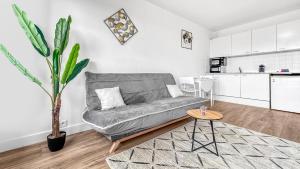 ein Wohnzimmer mit einem Sofa und einem Tisch in der Unterkunft ICE - Proche Gare - Wifi Gratuit - Baignoire in Gaillard