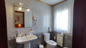 a bathroom with a sink and a toilet and a mirror at Casa David in Tríacastela