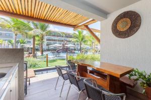 a patio with a table and chairs and a view of the pool at Praia Muro Alto paradisíaco, Flat de 2 quartos. in Porto De Galinhas