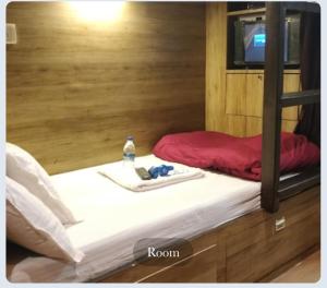 - un lit avec une bouteille d'eau dans l'établissement Hilal dormitory, à Mumbai