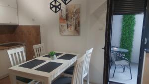 una mesa blanca y sillas en una cocina con una planta en Riverside apartment with private parking, en Niš