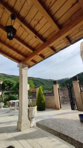 pérgola de madera con mesa y sillas en el patio en Casa David, en Triacastela