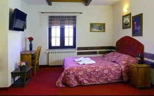 a bedroom with a purple bed with towels on it at Jaś Wędrowniczek in Rymanów