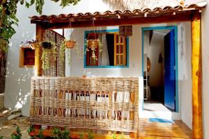 ジェリコアコアラにあるBarriga Da Lua Flatsの籐のポーチのある家 青い扉