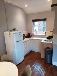 a small kitchen with a refrigerator and a sink at Self-contained Studio in Central London property Unit 4 in London