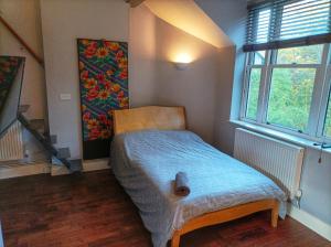 a small room with a bed with a blue blanket at Self-contained Studio in Central London property Unit 4 in London