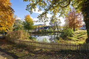 Ein Zaun neben einem Teich in einem Park. in der Unterkunft Gästehaus am Mühlenteich in Schieder-Schwalenberg