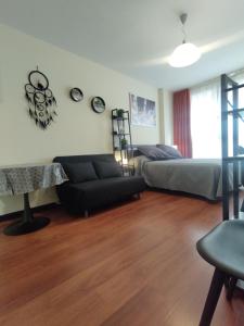 ein Wohnzimmer mit einem Sofa und einem Bett in der Unterkunft Madrid Office Tour Estudio Top in Alcobendas