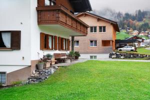 uma casa com um relvado verde em frente em Haus Bergfrieden em Au im Bregenzerwald