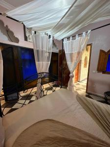 1 dormitorio con 1 cama con dosel blanco en Riad MAHJOUBA MARRAKECH & SPA, en Marrakech