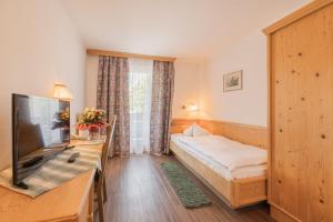 ein Hotelzimmer mit einem Bett und einem TV in der Unterkunft Batzenhäusl in Seefeld in Tirol