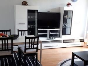 uma sala de estar com televisão e uma mesa com cadeiras em Haus Castellblick em Ballrechten