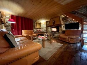 a living room with leather furniture and a fireplace at Chalet 1728 - La Reculaz - 2 minutes from Val D'isere in Tignes