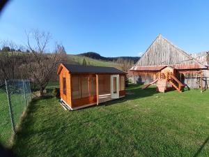 une petite cabine sur une pelouse à côté d'un bâtiment dans l'établissement Drevenica Deni, à Osturňa