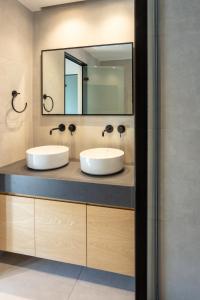 a bathroom with two sinks and a mirror at Nostos - Luxury Apartment in Agrinio in Agrinio
