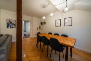 a dining room with a wooden table and black chairs at Old town apt in the heart of Thun with garden in Thun