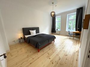 a bedroom with a bed and a wooden floor at Park Lane Business-Apartment in Hamburg