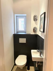 a bathroom with a white toilet and a sink at Park Lane Business-Apartment in Hamburg